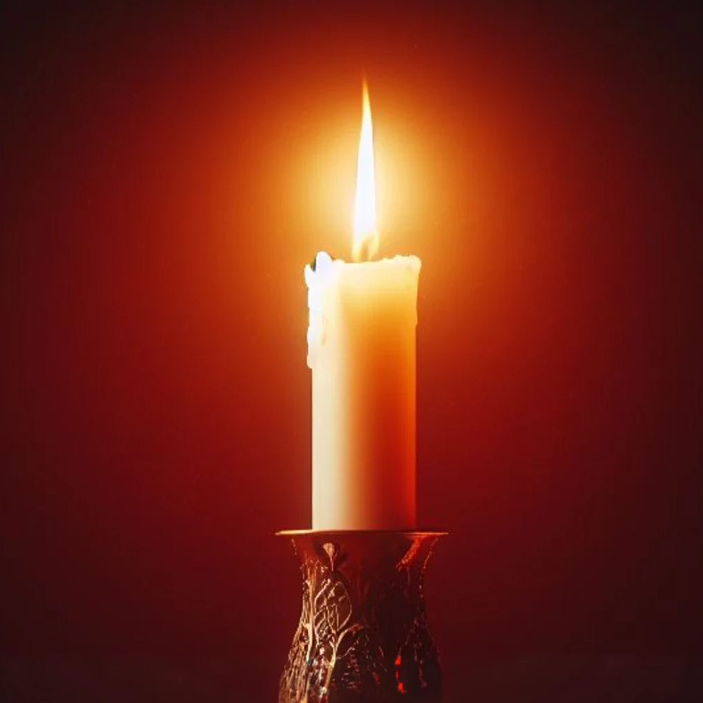 Single candle glowing in the dark